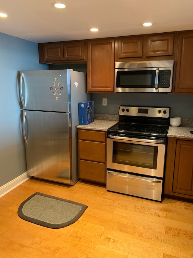 kitchen featuring stainless steel appliances and light hardwood / wood-style floors