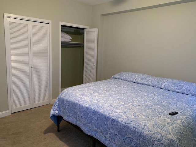 carpeted bedroom featuring multiple closets