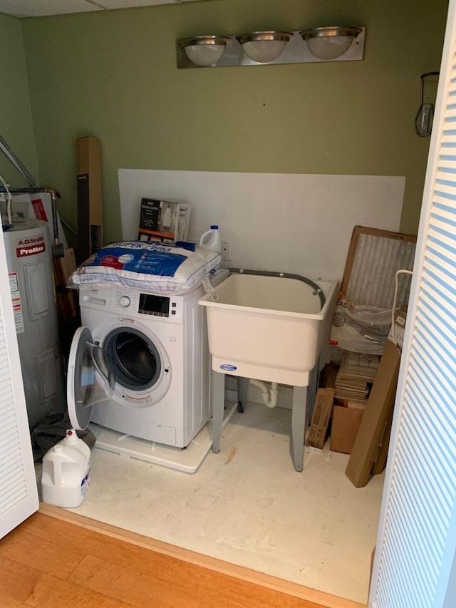 laundry area with washer / clothes dryer, sink, light hardwood / wood-style floors, and electric water heater