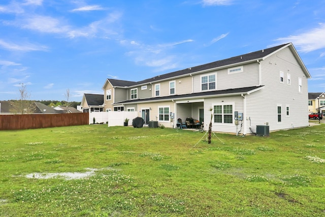 rear view of property featuring a yard and central AC