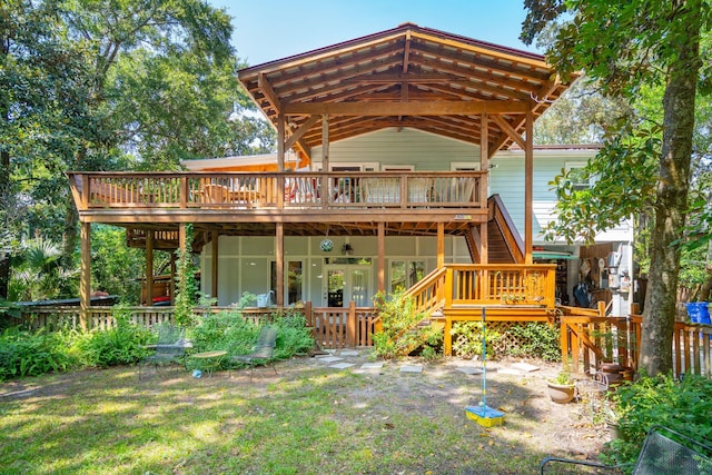 rear view of house with a lawn and a wooden deck