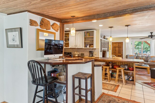 kitchen with tasteful backsplash, kitchen peninsula, light tile patterned floors, and ceiling fan