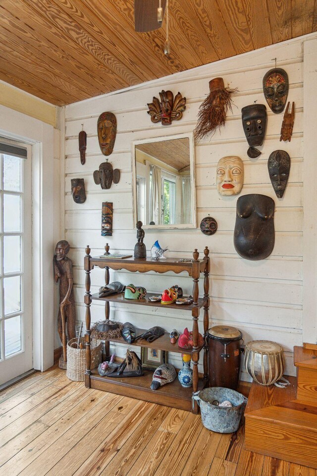 interior details featuring wood walls, wooden ceiling, and hardwood / wood-style flooring