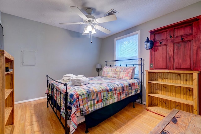 bedroom featuring a textured ceiling, ceiling fan, and light hardwood / wood-style floors