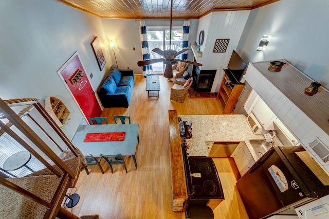 living room with ornamental molding, a fireplace, and wood-type flooring