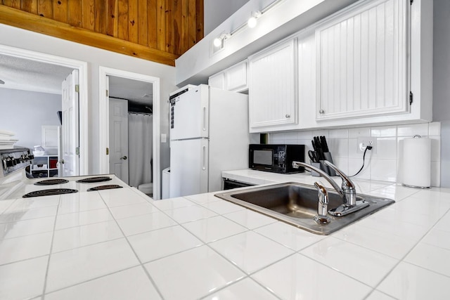 kitchen with tile counters, white cabinets, white appliances, and sink