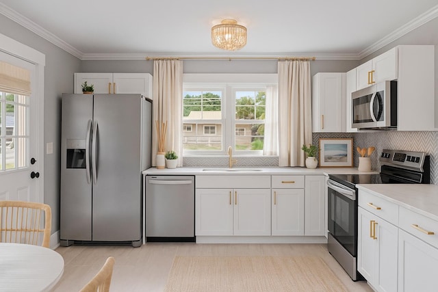 1312 Congress St, Beaufort, SC 29902 - kitchen with appliances with stainless steel finishes, plenty of natural light, light countertops, white cabinetry, and ornamental molding