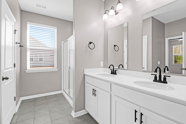 full bath featuring double vanity, a sink, visible vents, and a shower stall