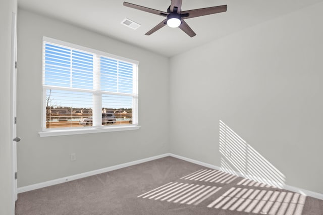 empty room featuring ceiling fan, carpet, visible vents, and baseboards