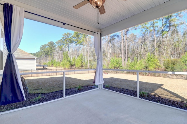 unfurnished sunroom with a ceiling fan