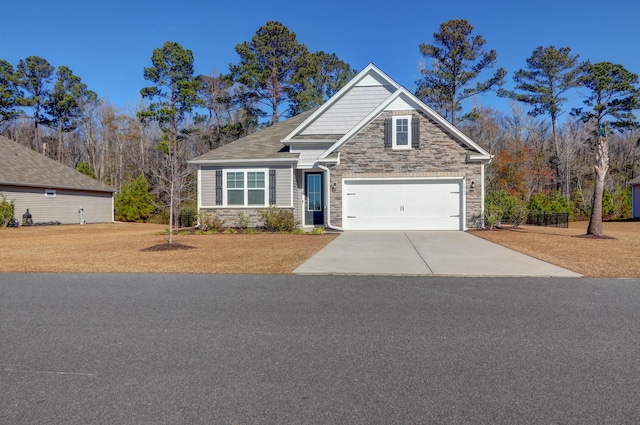 craftsman-style home with a garage, stone siding, and driveway