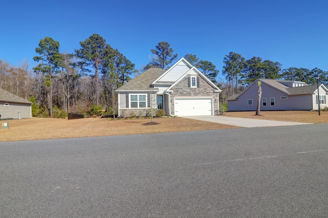 view of front of house with a garage, stone siding, and driveway