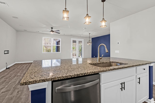 kitchen with stone counters, a sink, visible vents, white cabinets, and stainless steel dishwasher