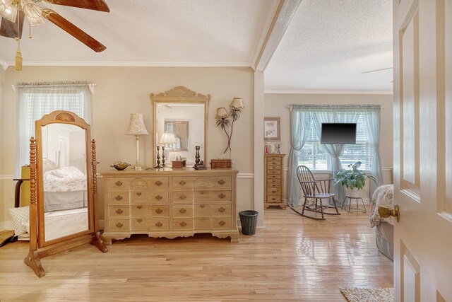 interior space featuring a textured ceiling, light hardwood / wood-style flooring, ceiling fan, and crown molding