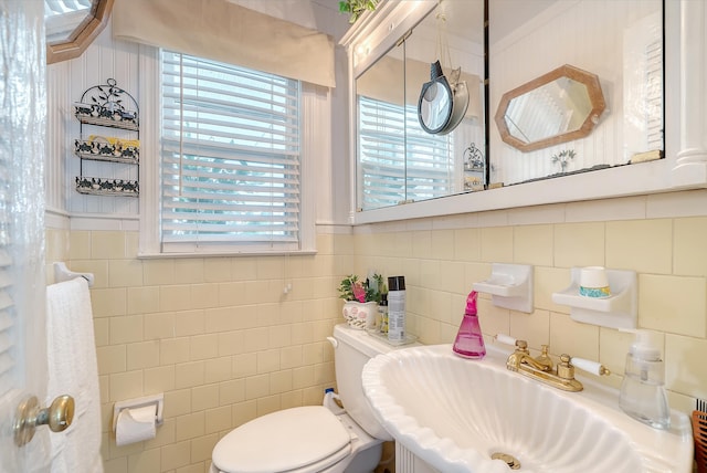 bathroom featuring tile walls, backsplash, toilet, and sink