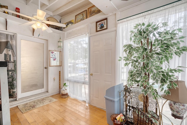 foyer entrance with light wood-type flooring, plenty of natural light, beam ceiling, and ceiling fan