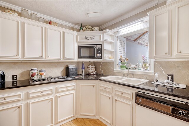 kitchen with dishwasher, crown molding, black microwave, light wood-type flooring, and sink