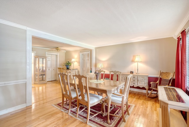 dining room featuring ceiling fan, crown molding, a textured ceiling, and light hardwood / wood-style flooring