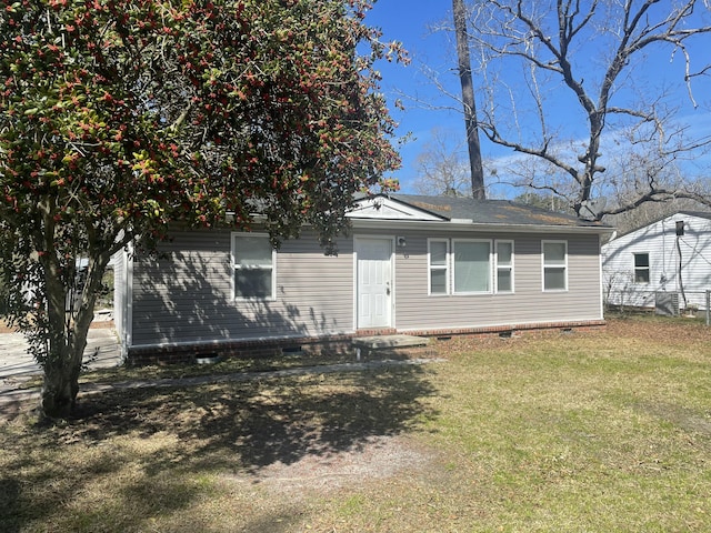 rear view of house with crawl space and a lawn