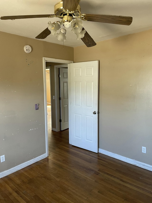 spare room featuring a ceiling fan, baseboards, and wood finished floors