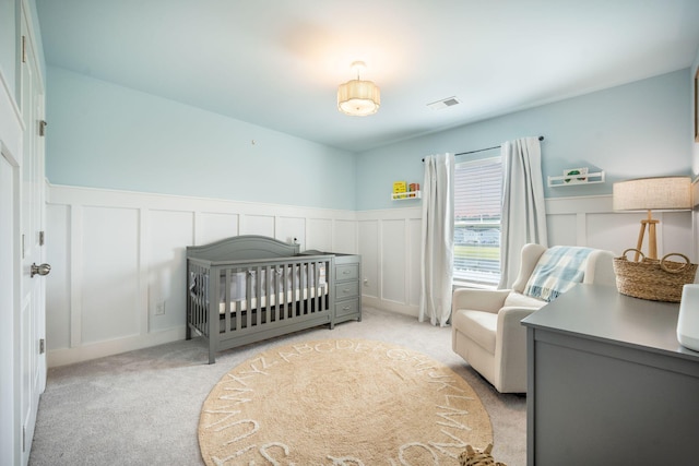 705 Squire Pope Rd, Summerville, SC 29486 - bedroom featuring a decorative wall, light colored carpet, wainscoting, and a crib