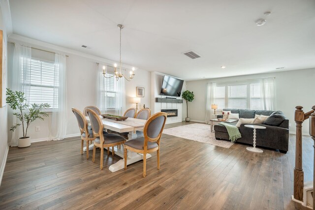 705 Squire Pope Rd, Summerville, SC 29486 - dining space featuring hardwood / wood-style floors, plenty of natural light, a tiled fireplace, and a chandelier