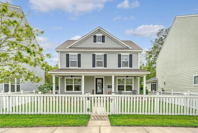 view of front of house featuring roof with shingles, a front lawn, a fenced front yard, a gate, and covered porch