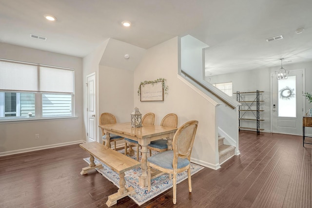 dining room with plenty of natural light, stairs, dark wood-type flooring, and visible vents