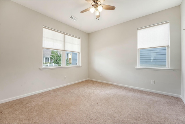 unfurnished room with carpet floors, ceiling fan, visible vents, and baseboards