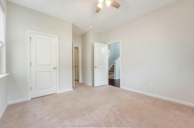 unfurnished bedroom with carpet, visible vents, baseboards, and a ceiling fan