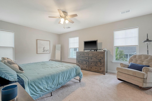 carpeted bedroom featuring baseboards, a ceiling fan, and visible vents