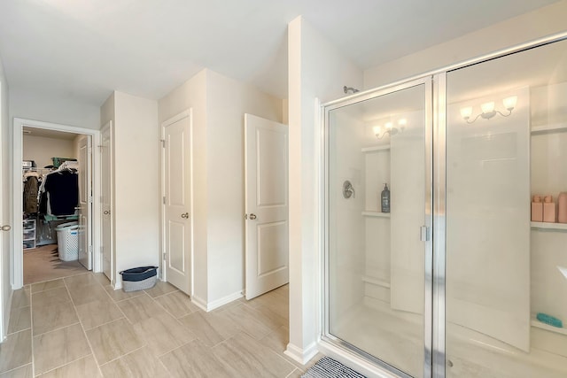 full bath featuring a shower stall and a walk in closet