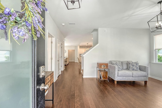 sitting room with visible vents, baseboards, an inviting chandelier, dark wood-style floors, and stairs