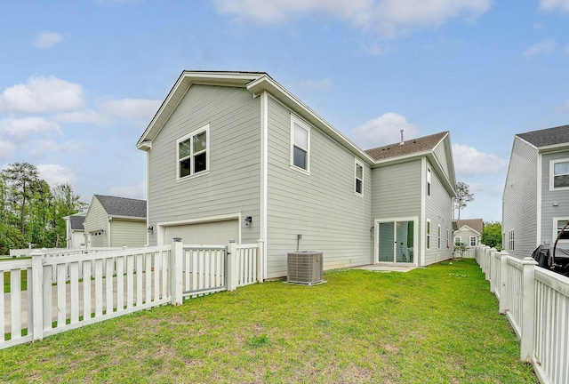 back of house featuring a garage, central AC unit, a fenced backyard, and a lawn
