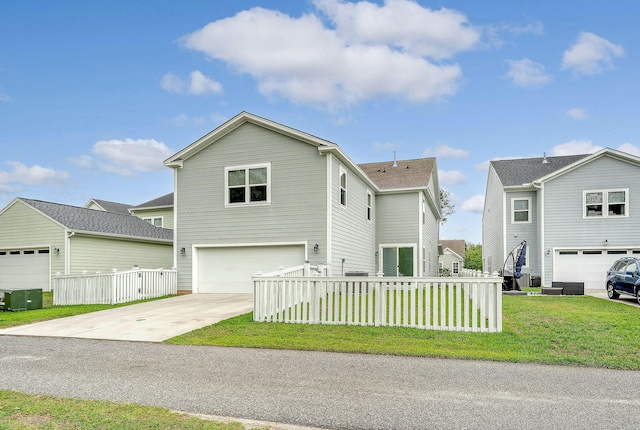 traditional-style home with central AC, fence, a front lawn, a garage, and driveway