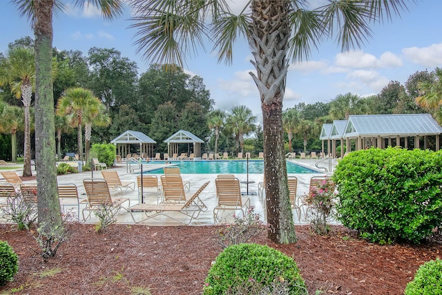 community pool with a gazebo and a patio