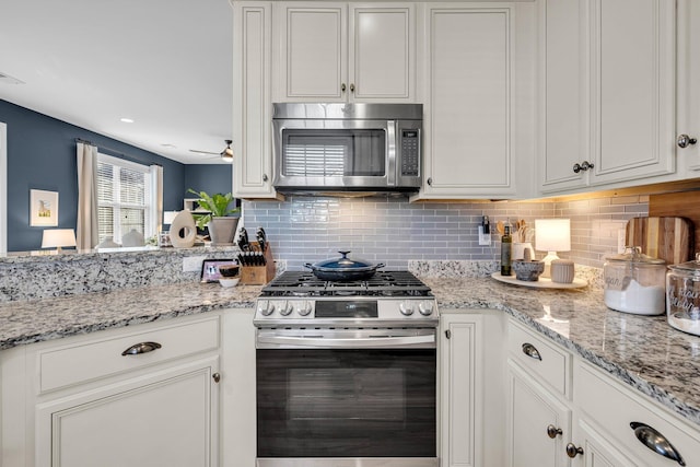 kitchen with backsplash, appliances with stainless steel finishes, and white cabinetry