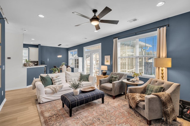 living room featuring ceiling fan and light hardwood / wood-style flooring