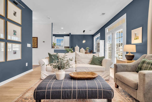 living room featuring crown molding and light wood-type flooring