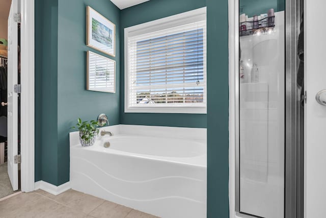 bathroom with tile patterned floors and shower with separate bathtub