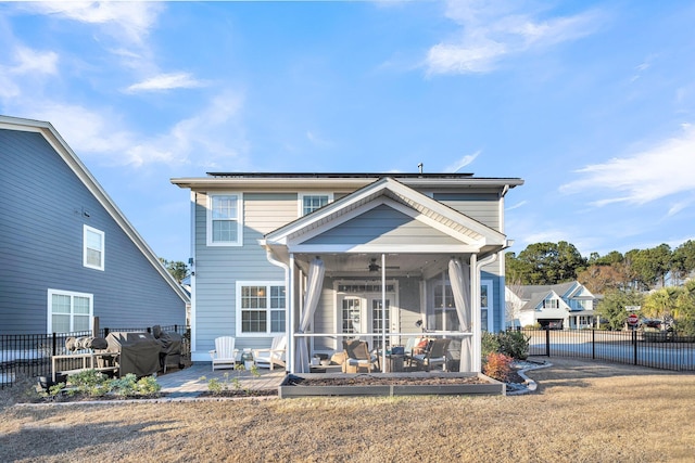 view of front of property with ceiling fan, a front lawn, a patio area, and a sunroom