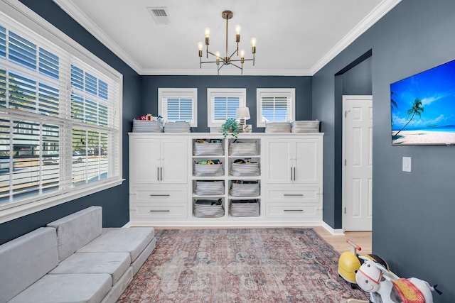 sitting room featuring ornamental molding, light hardwood / wood-style floors, and a notable chandelier