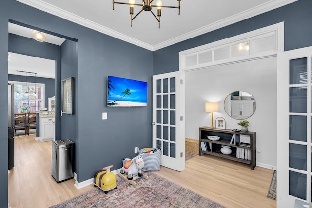 miscellaneous room with french doors, ornamental molding, a chandelier, and light hardwood / wood-style floors