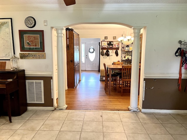 hallway with crown molding, wood-type flooring, a textured ceiling, and a notable chandelier