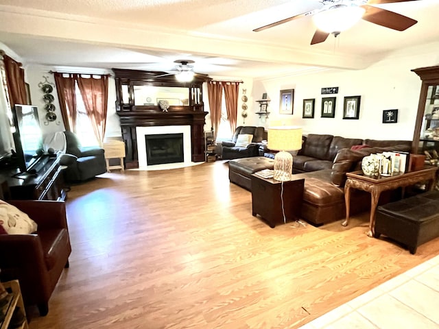 living room with beam ceiling, ceiling fan, and wood-type flooring