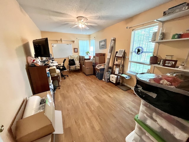 misc room featuring a textured ceiling, light hardwood / wood-style floors, and ceiling fan