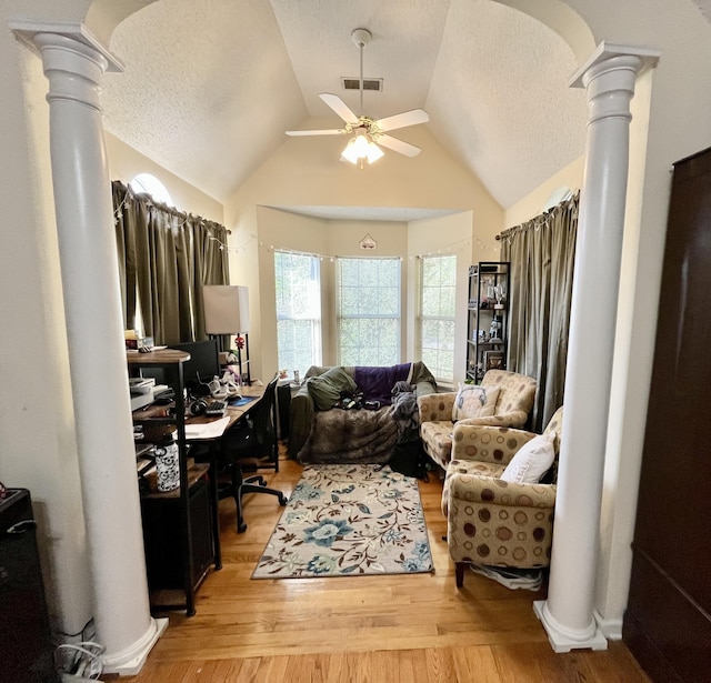 office space featuring ornate columns, a textured ceiling, ceiling fan, light hardwood / wood-style flooring, and lofted ceiling