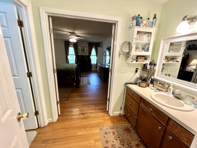 bathroom featuring ceiling fan, vanity, and wood-type flooring