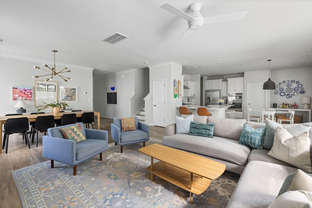 1825 Crossbill Trl, Hanahan, SC 29410 - living area with wood finished floors, stairway, a chandelier, ornamental molding, and ceiling fan