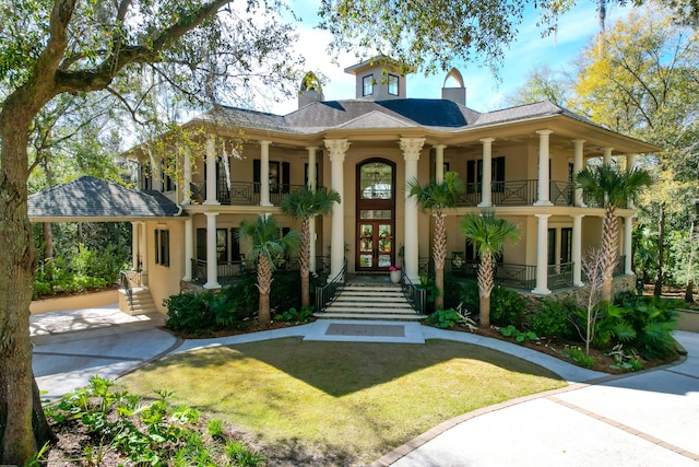 view of front of home with french doors, a front lawn, and a porch